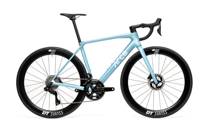 An ARC8 Escapee DB road bike in ice blue color with black wheels and tires, featuring a lightweight frame and a DT SWISS wheel system.